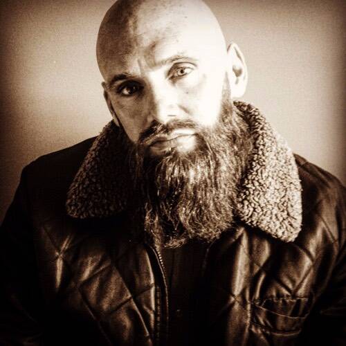 A man with a beard wearing a jacket.